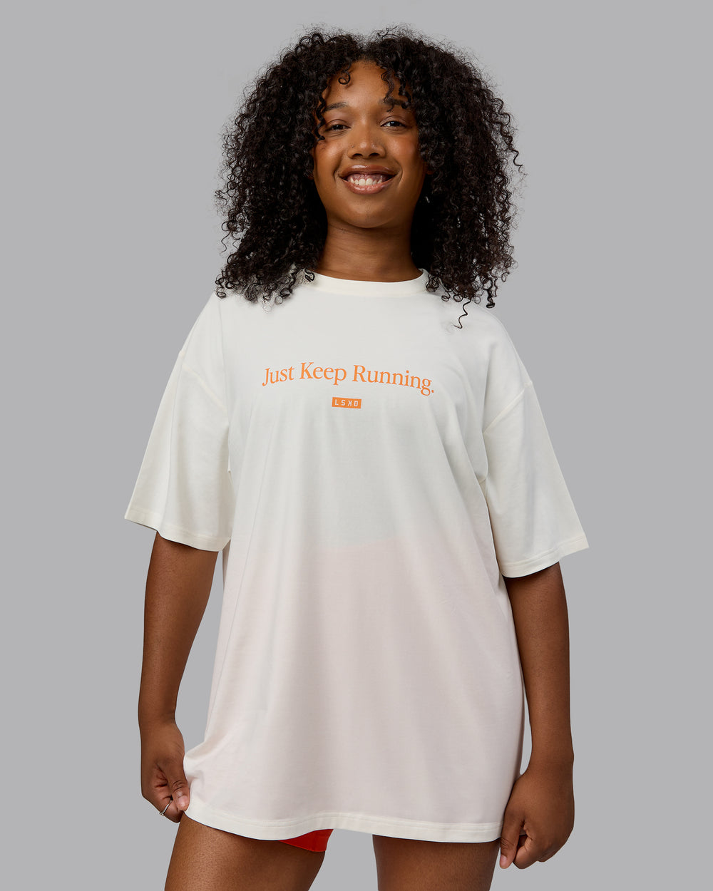 Woman wearing Unisex Just Keep Running FLXCotton Tee Oversize - Off White-Vibrant Orange