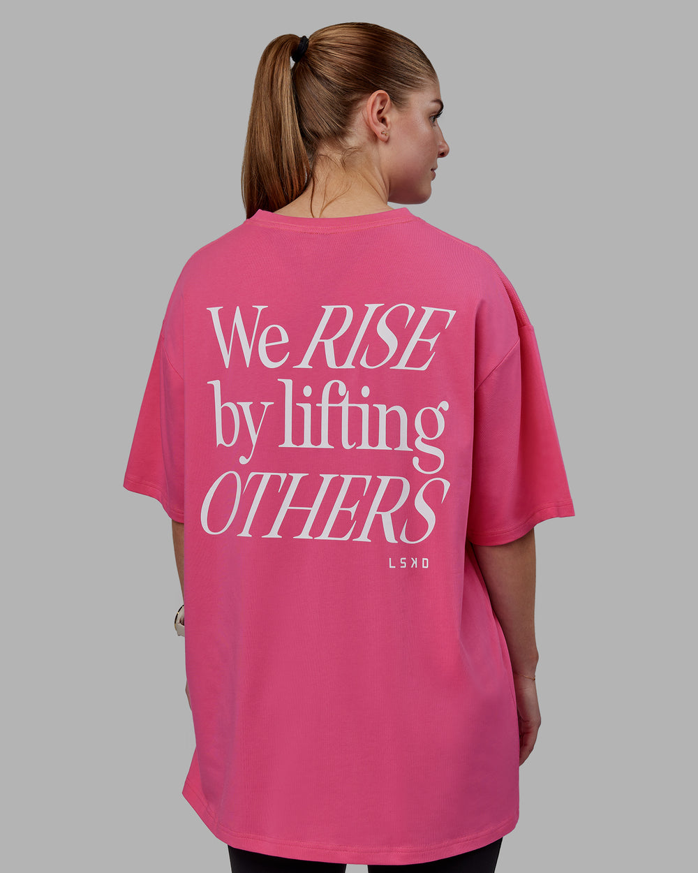 Woman wearing Unisex Lift-Up FLXCotton Tee Oversize - Carmine Rose-White