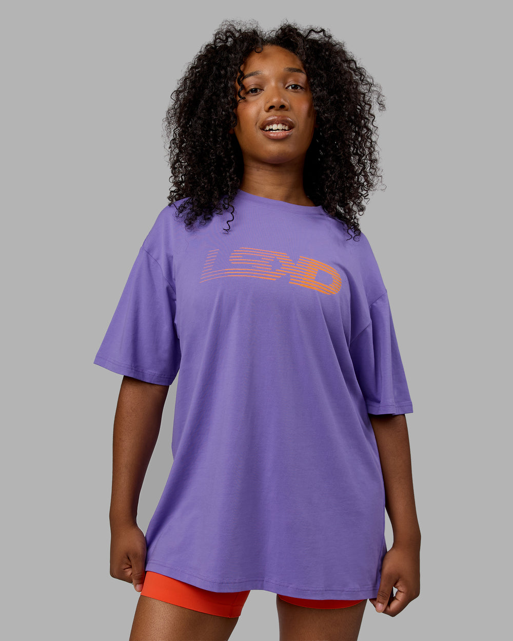 Woman wearing Unisex Motion FLXCotton Tee Oversize - Dahlia Purple-Vibrant Orange