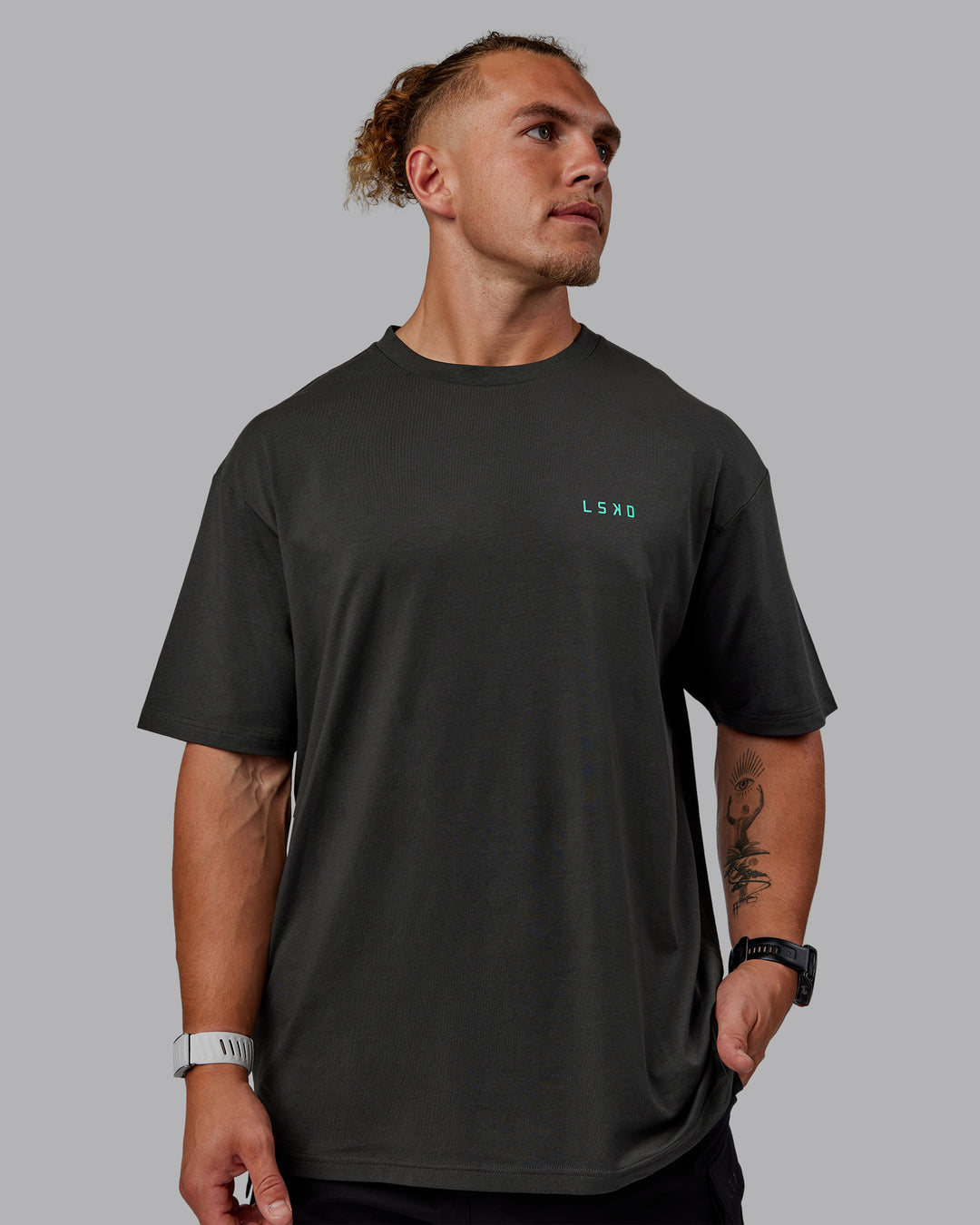 Man wearing Unisex Strike Through FLXCotton Tee Oversize - Pirate Black-Impact Green