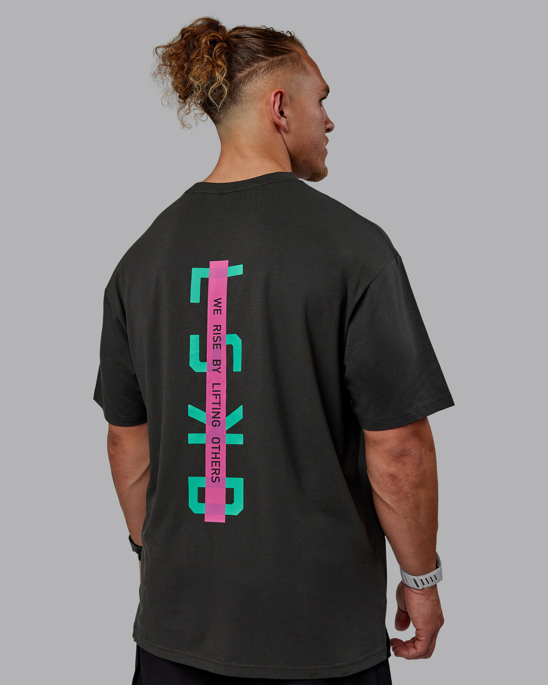 Man wearing Unisex Strike Through FLXCotton Tee Oversize - Pirate Black-Impact Green