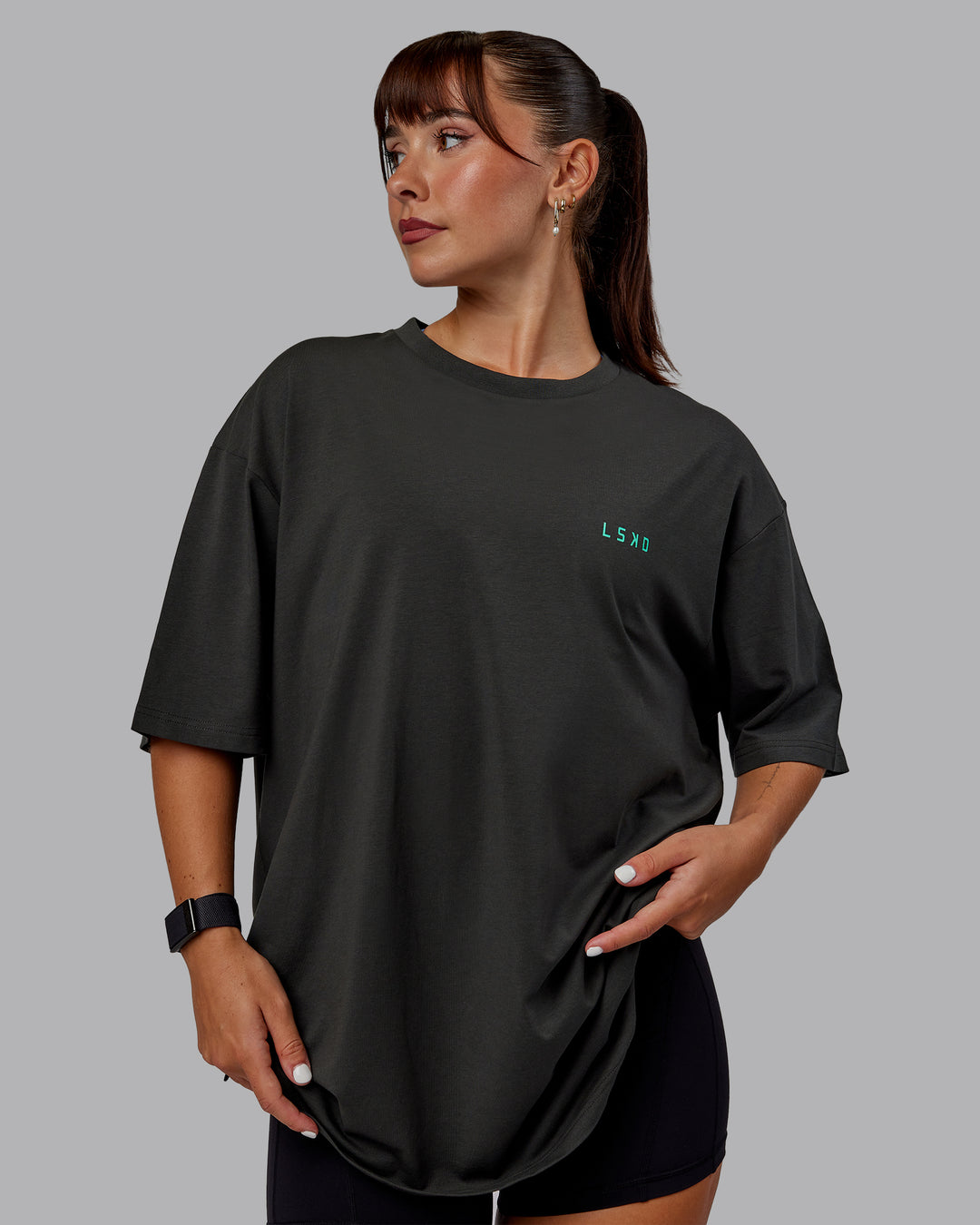 Woman wearing Unisex Strike Through FLXCotton Tee Oversize - Pirate Black-Impact Green