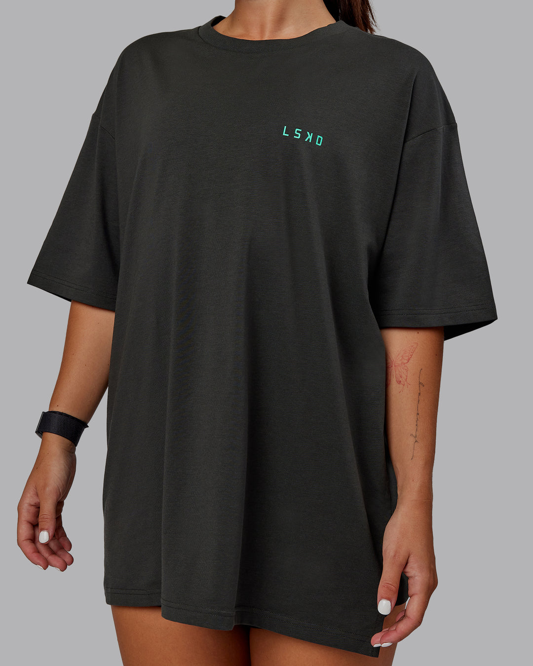 Woman wearing Unisex Strike Through FLXCotton Tee Oversize - Pirate Black-Impact Green