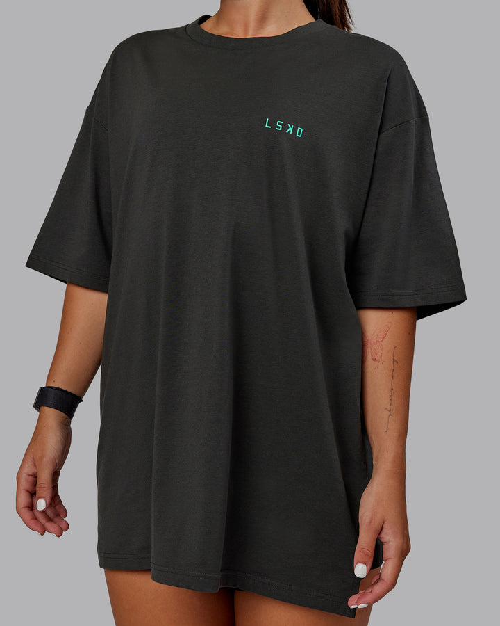 Woman wearing Unisex Strike Through FLXCotton Tee Oversize - Pirate Black-Impact Green
