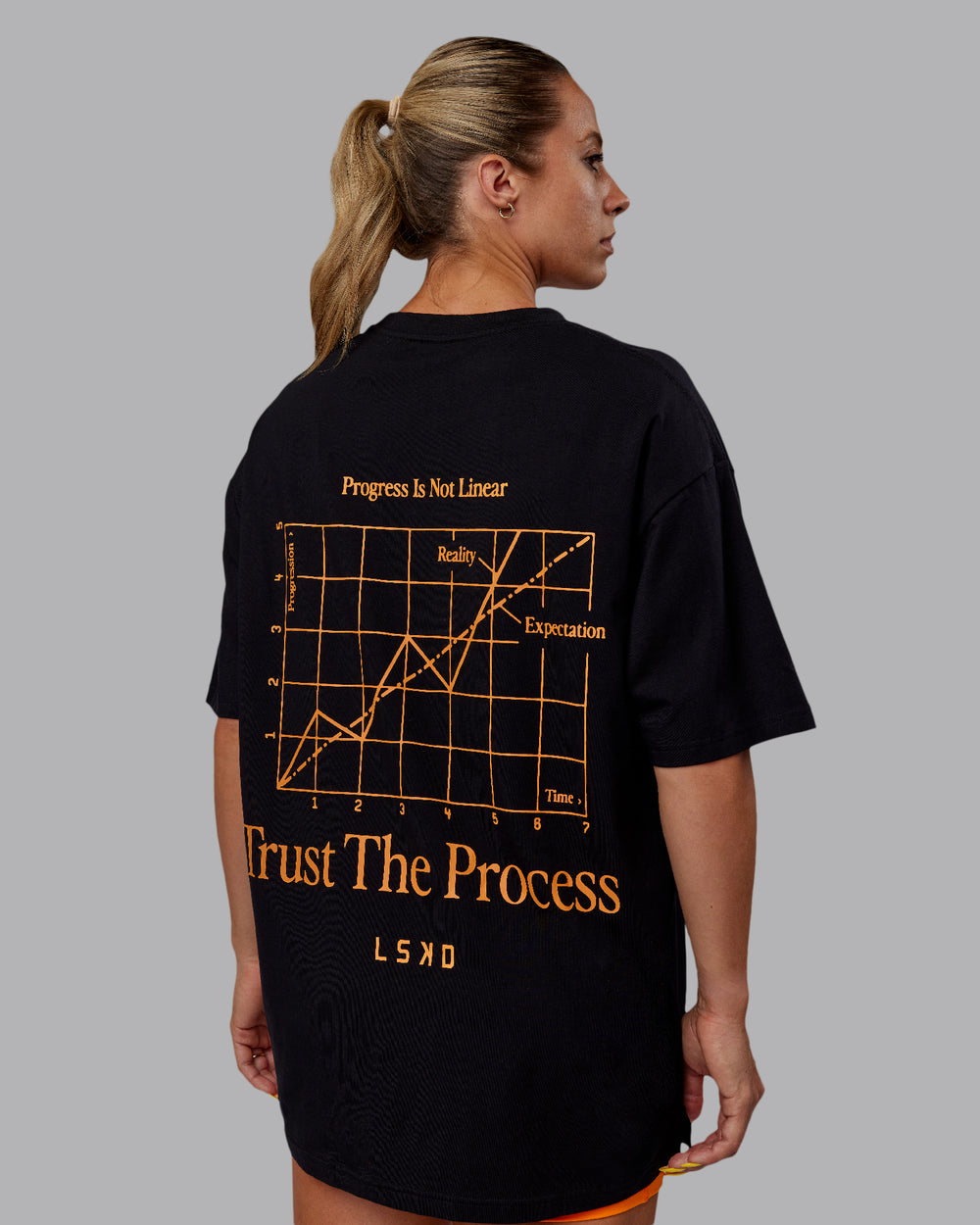 Woman wearing Unisex Trust The Process 2.0 FLXCotton Tee Oversize - Black-Vibrant Orange