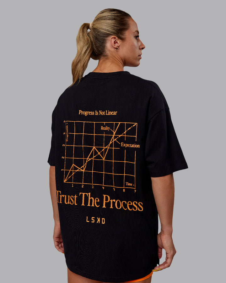 Woman wearing Unisex Trust The Process 2.0 FLXCotton Tee Oversize - Black-Vibrant Orange
