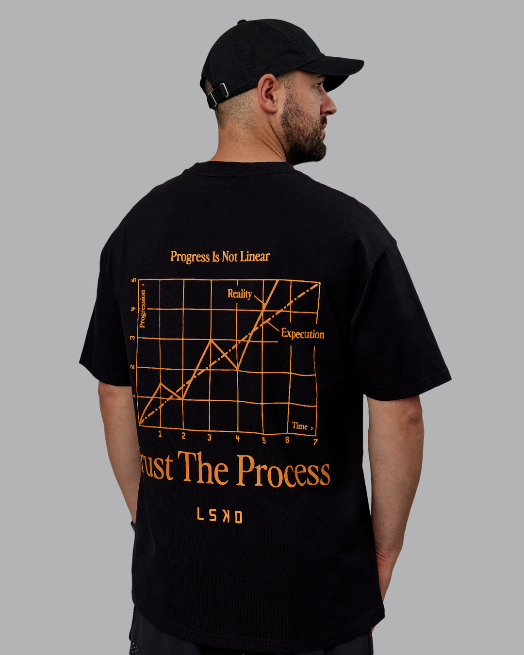 Man wearing Unisex Trust The Process 2.0 FLXCotton Tee Oversize - Black-Vibrant Orange