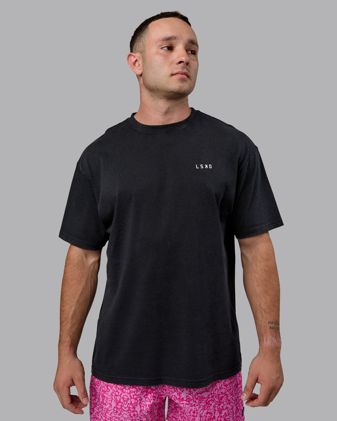 Man wearing Unisex Washed Empower Tee Oversize - Black-Berry Pink