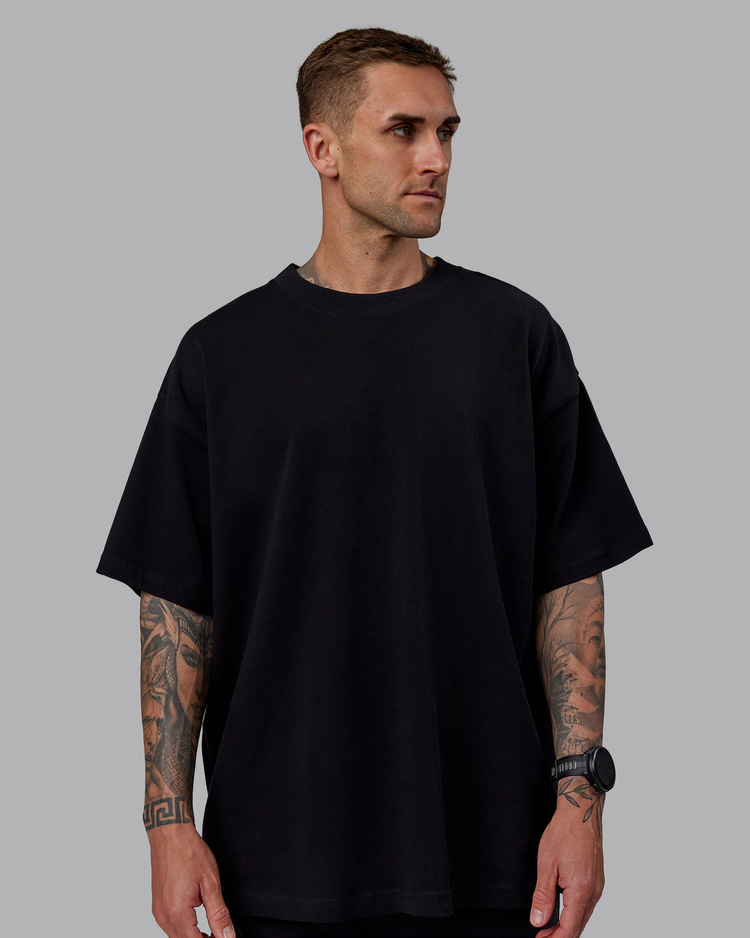 Man wearing Unisex We Rise Heavyweight Tee Oversize - Black-Impact Green