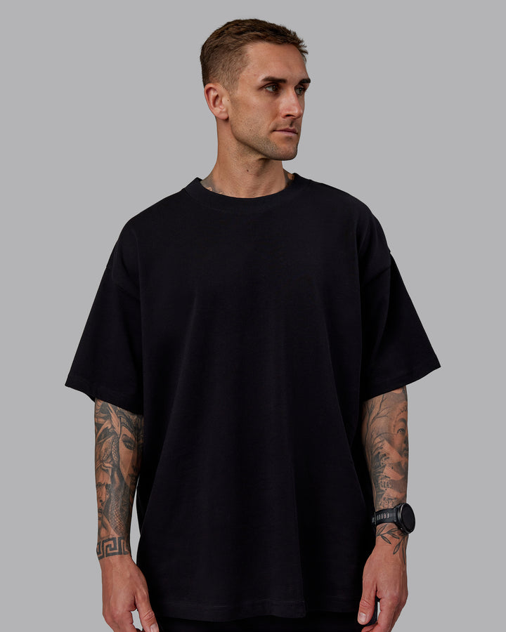 Man wearing Unisex We Rise Heavyweight Tee Oversize - Black-Impact Green
