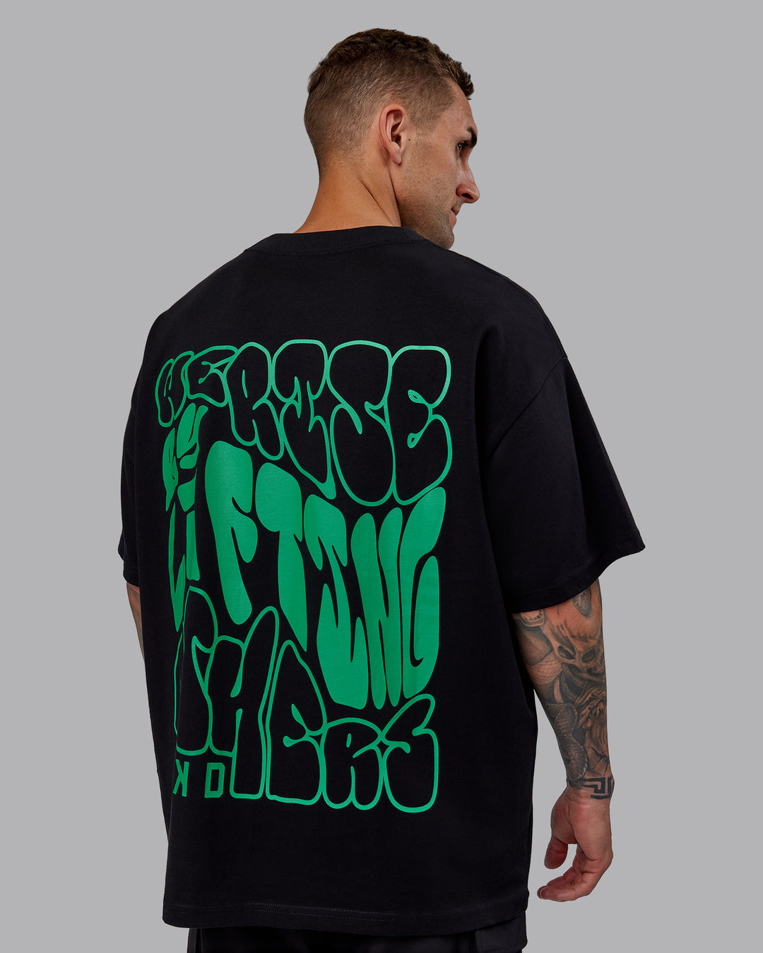 Man wearing Unisex We Rise Heavyweight Tee Oversize - Black-Impact Green