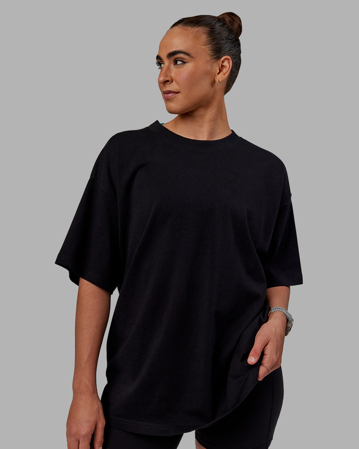 Woman wearing Unisex We Rise Heavyweight Tee Oversize - Black-Impact Green
