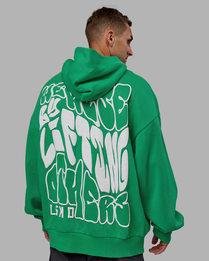 Man wearing Unisex We Rise Hoodie Oversize - Impact Green-White
