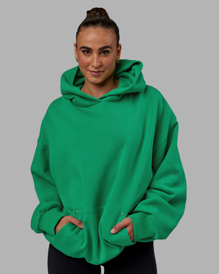 Woman wearing Unisex We Rise Hoodie Oversize - Impact Green-White
