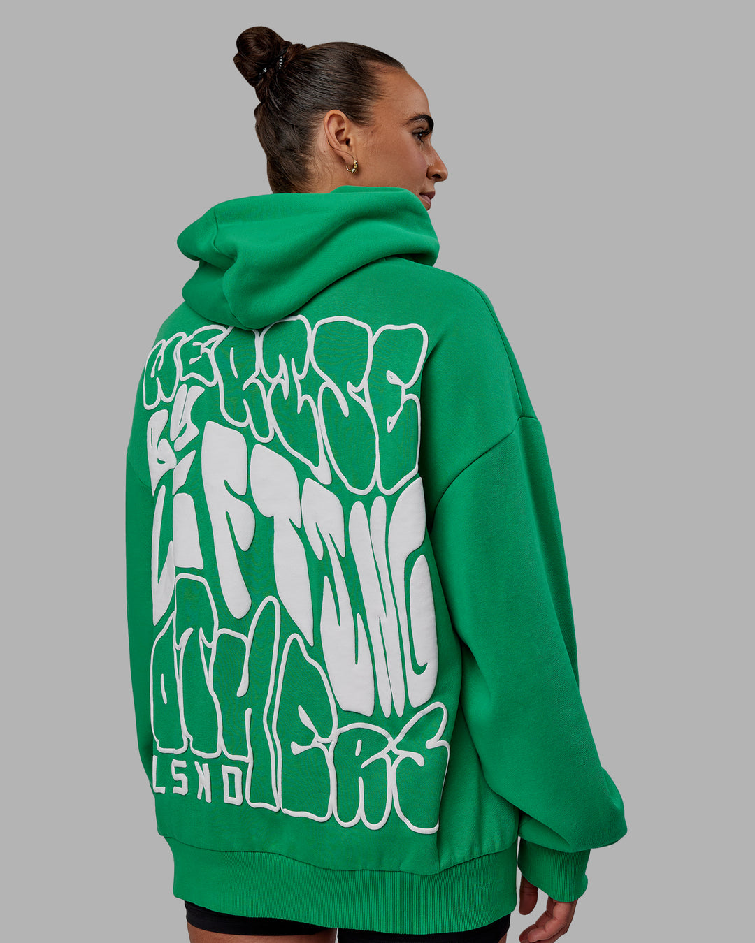 Woman wearing Unisex We Rise Hoodie Oversize - Impact Green-White