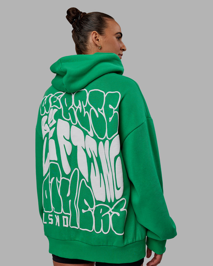 Woman wearing Unisex We Rise Hoodie Oversize - Impact Green-White
