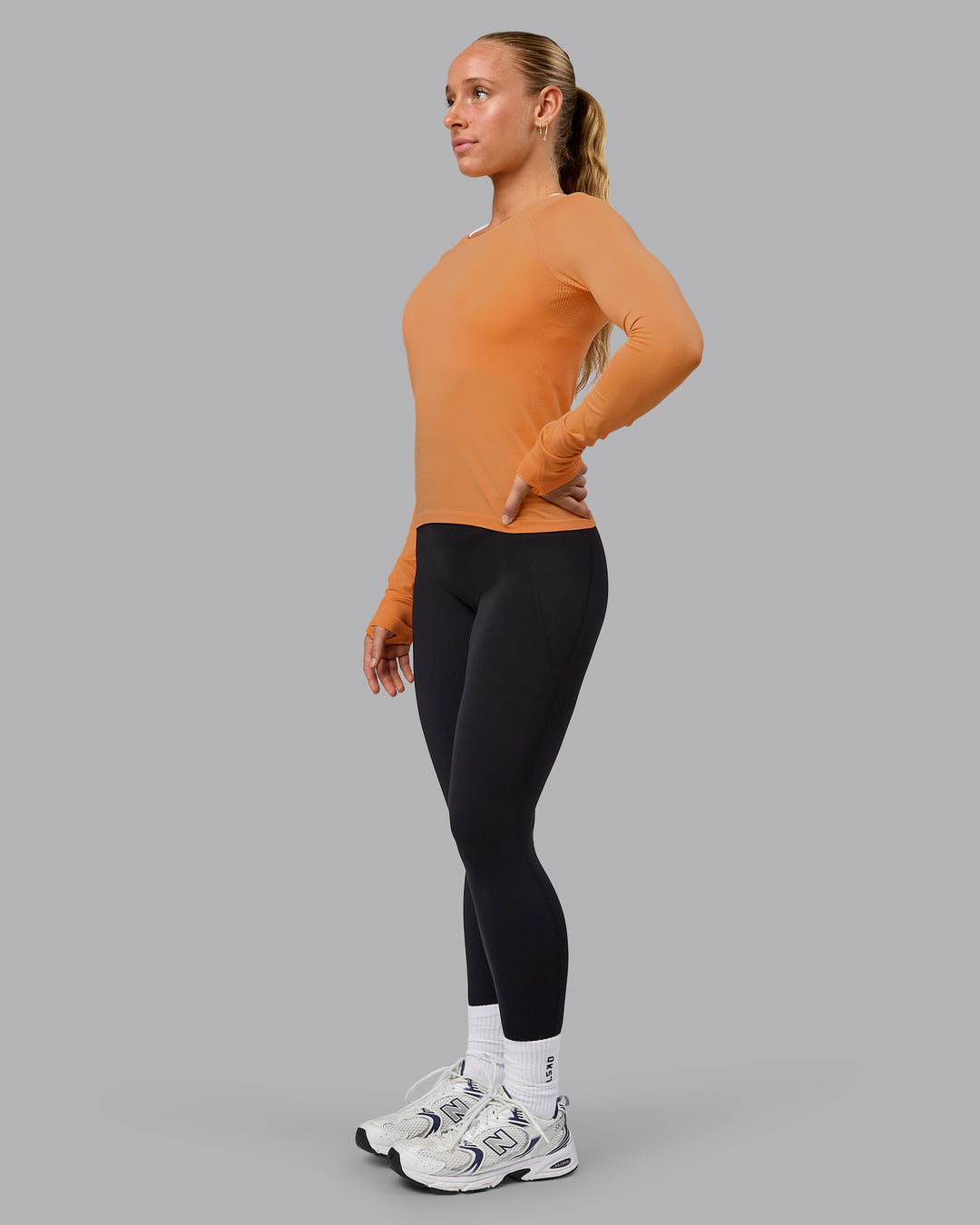 Woman wearing AeroFLX+ Seamless Long Sleeve Tee - Cantaloupe