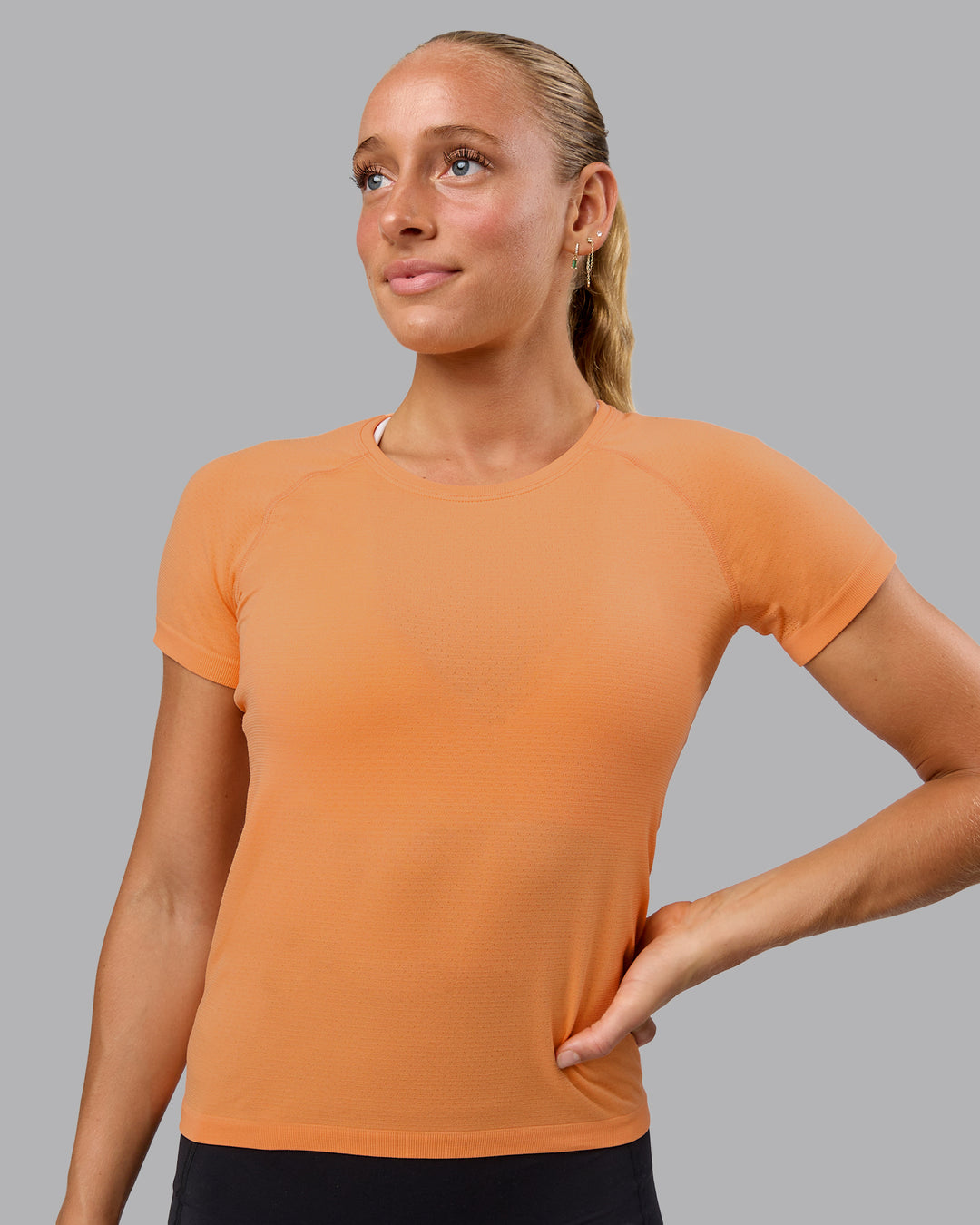 Woman wearing AeroFLX+ Seamless Tee - Cantaloupe