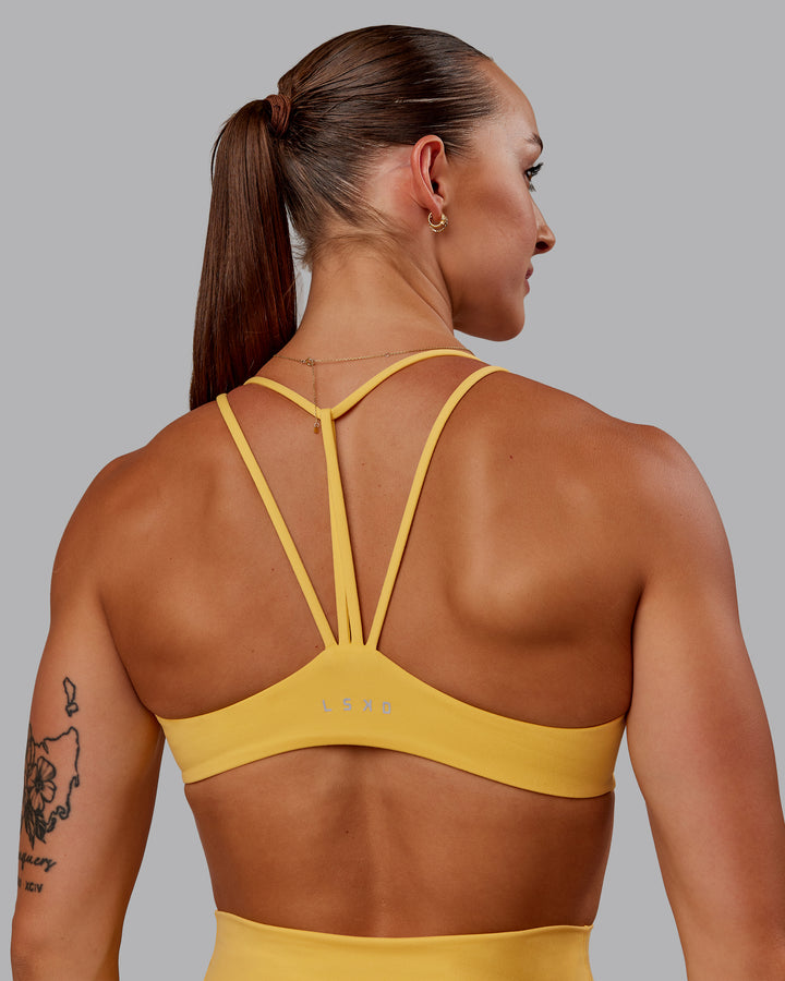 Woman wearing Agile Sports Bra in Banana Cream | Size:S
