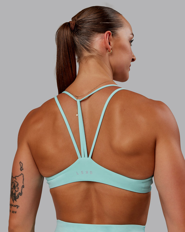 Woman wearing Agile Sports Bra in Island Paradise | Size:S
