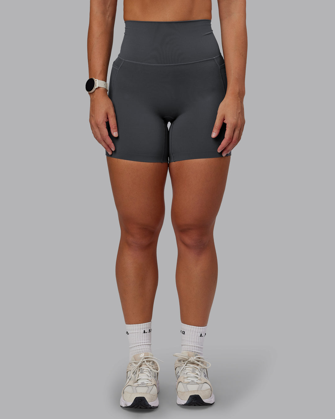 Woman wearing Elixir Mid Short Tight With Pockets in Dark Storm | Size:S