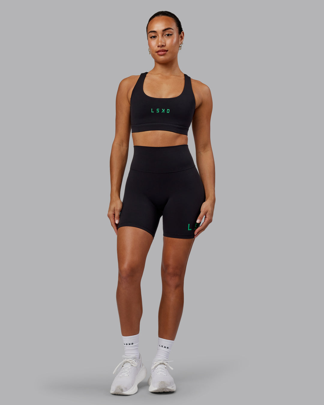 Woman wearing Evolved Mid Short Tights - Black-Impact Green