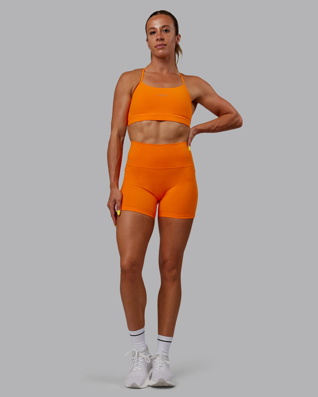 Woman wearing Lift Sports Bra - Vibrant Orange