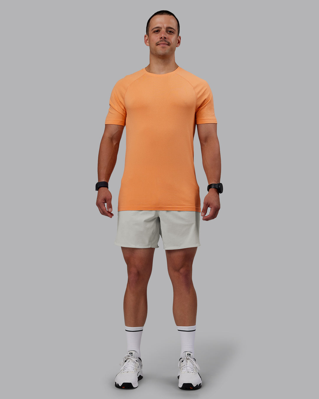 Man wearing AeroFLX+ Seamless Tee - Cantaloupe/Cantaloupe Marl