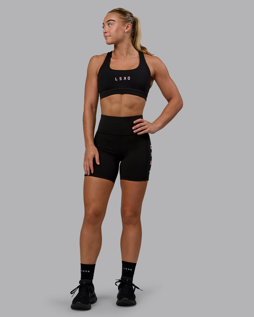 Woman wearing Rep Sports Bra - Black-Bubblegum