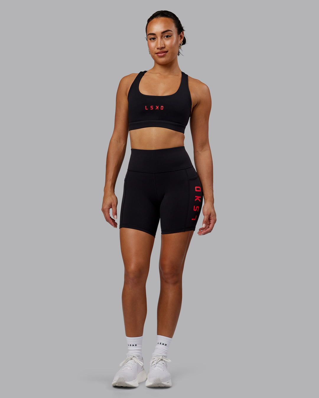 Woman wearing Rep Sports Bra - Black-Scarlet