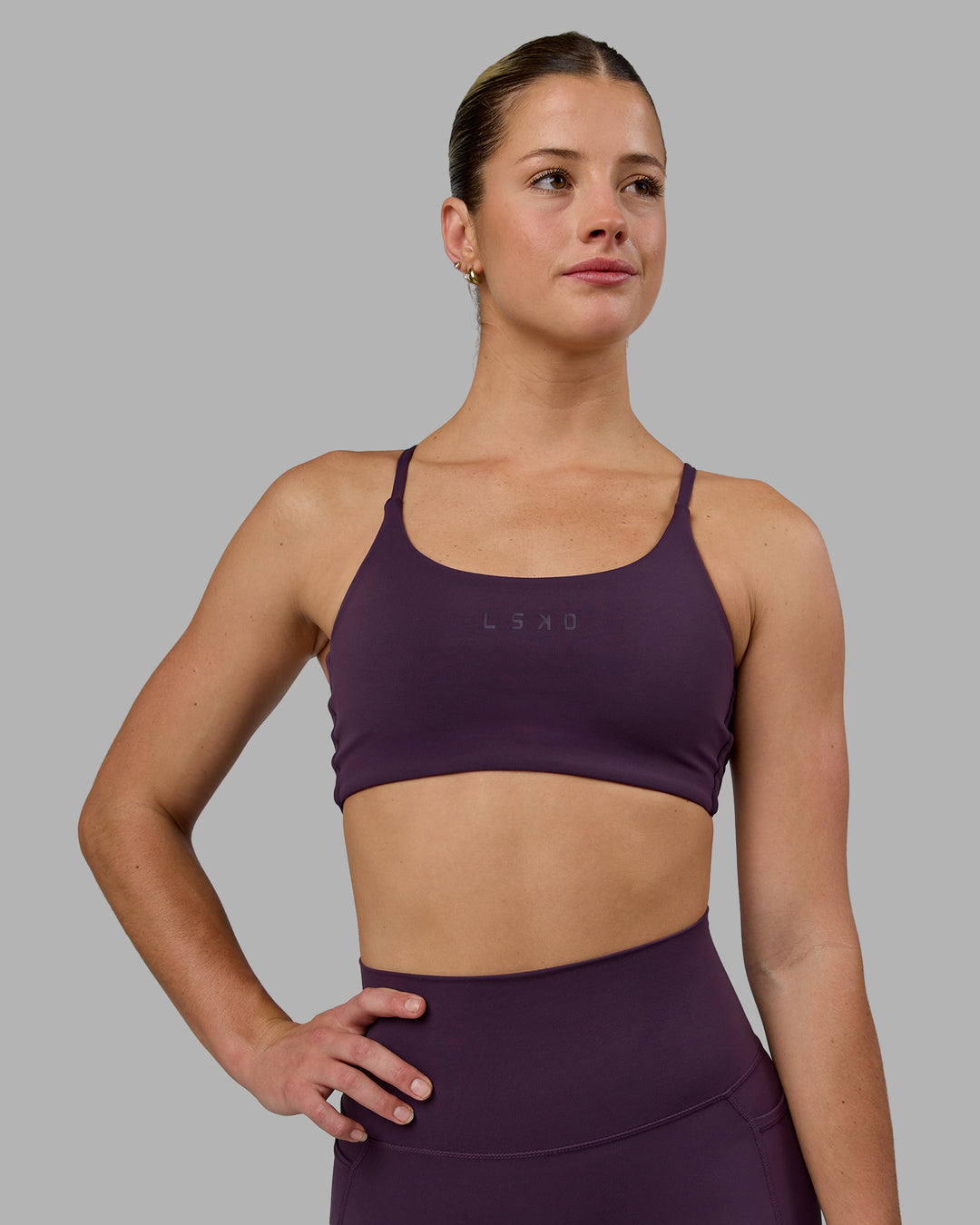 Woman wearing Twist Sports Bra - Midnight Plum