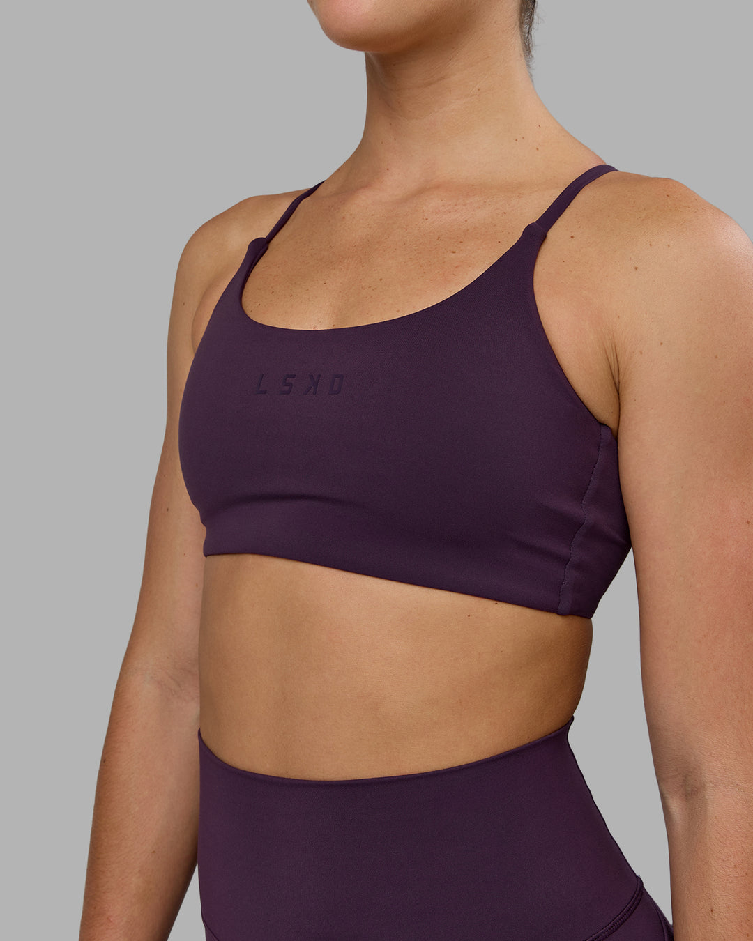 Woman wearing Twist Sports Bra - Midnight Plum