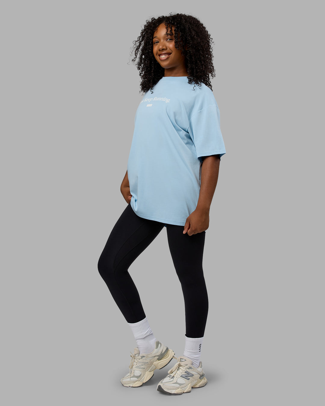 Woman wearing Unisex Just Keep Running FLXCotton Tee Oversize - Glacial Blue-Off White