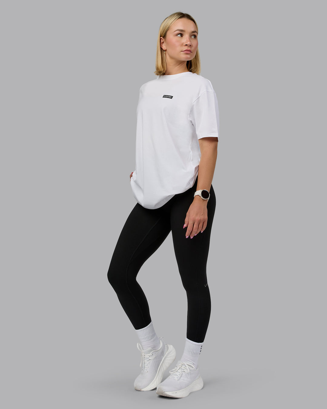 Woman wearing Fitstop Embrace the Sweat FLXCotton Oversized Tee in White-Black | Size:XS