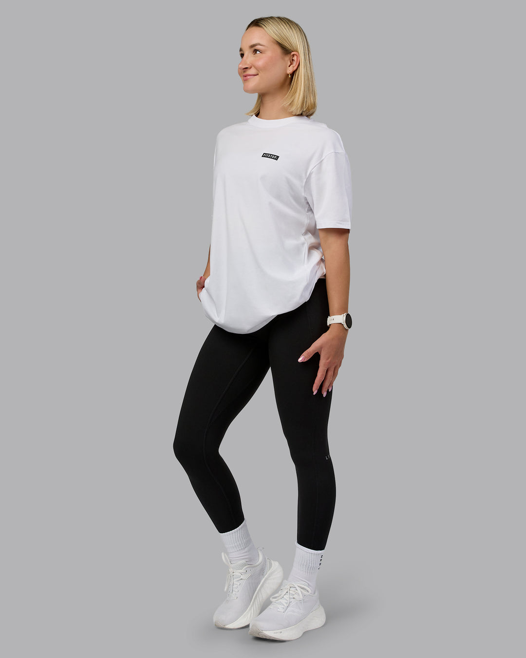 Woman wearing Fitstop Embrace the Sweat FLXCotton Oversized Tee in White-Black | Size:XS