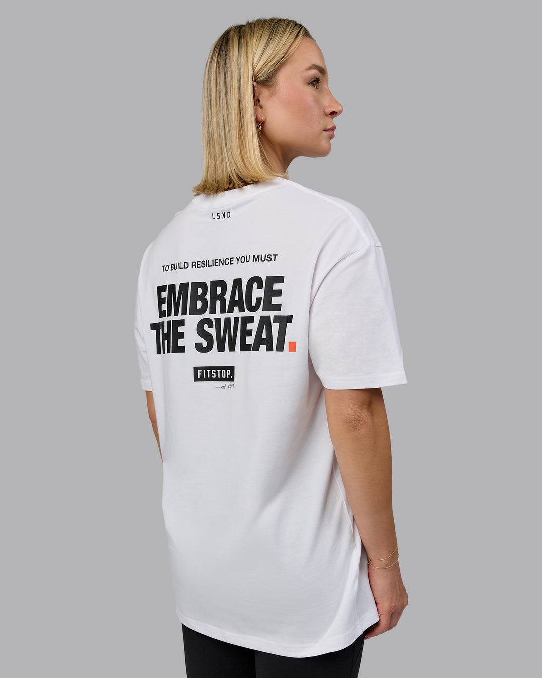 Woman wearing Fitstop Embrace the Sweat FLXCotton Oversized Tee in White-Black | Size:XS