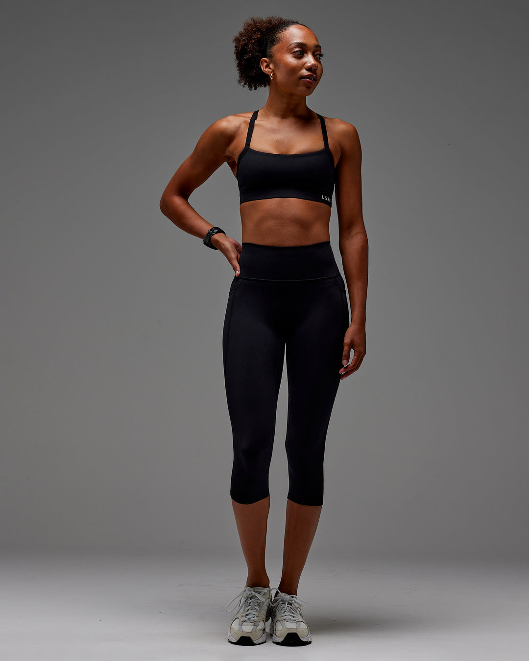 Woman wearing Fusion 3/4 Length Tight with Pockets in Black | Model:Txai | Size:XS