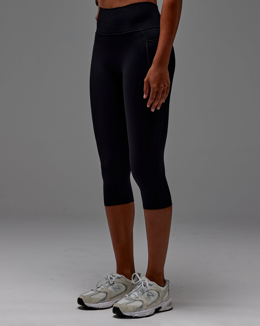 Woman wearing Fusion 3/4 Length Tight with Pockets in Black | Model:Txai | Size:XS