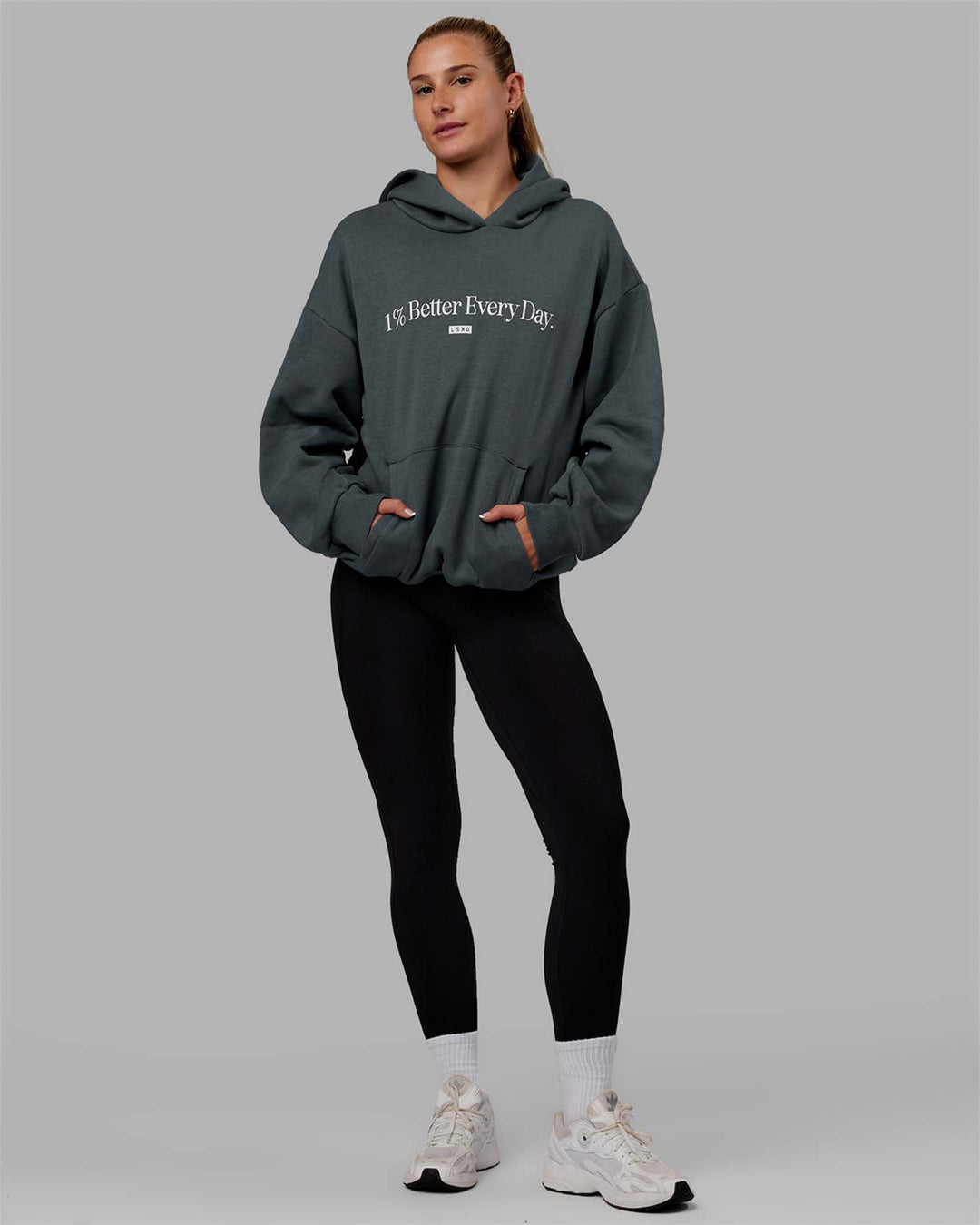 Woman wearing Unisex 1% Better Hoodie Oversize - Storm-White