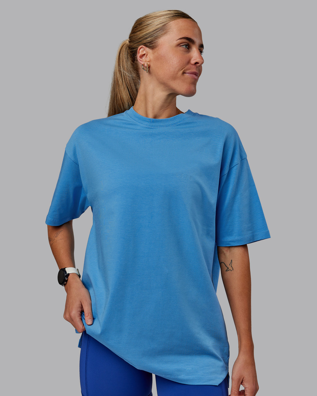 Woman wearing Unisex PimaFLX Tee Oversize in Azure Blue | Size:XS