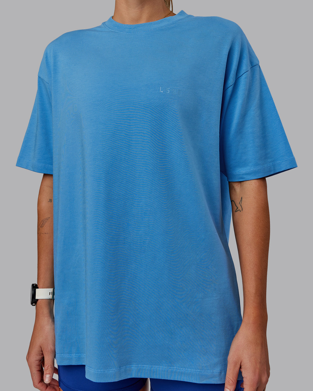 Woman wearing Unisex PimaFLX Tee Oversize in Azure Blue | Size:XS